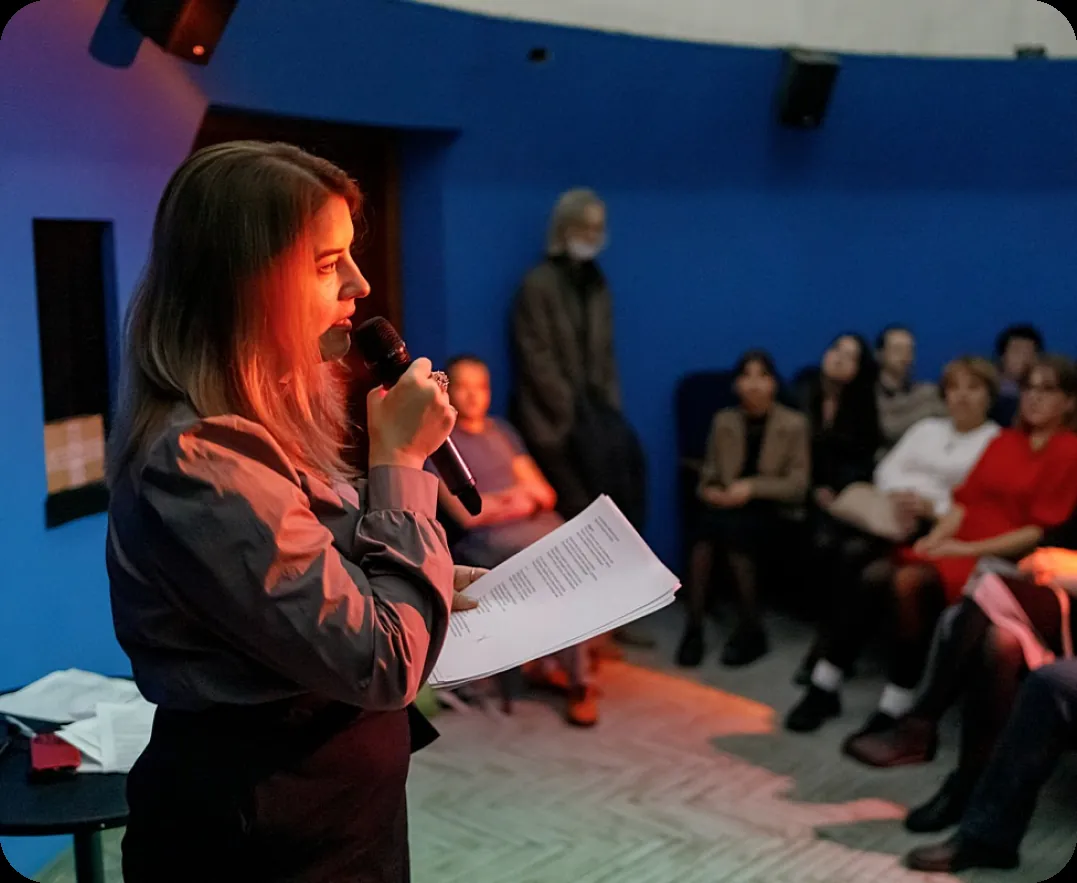 Ученица выступает с микрофоном перед зрителями
